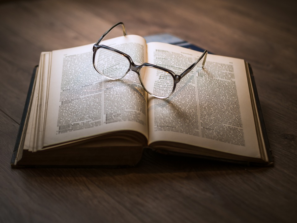 Paire de lunettes loupes posée sur un livre ouvert pour mieux voir